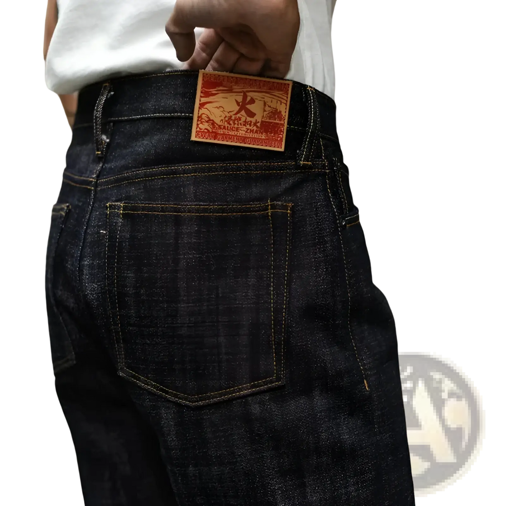 Dark indigo Saucezhan Fire Selvedge tapered raw denim jeans with red and brown leather patch at the waistband back side