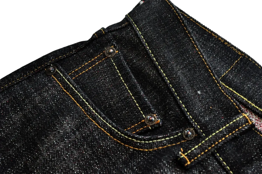 Sauceszhan fire selvedge tapered raw denim jeans in dark indigo with yellow stitching and silver metal rivets