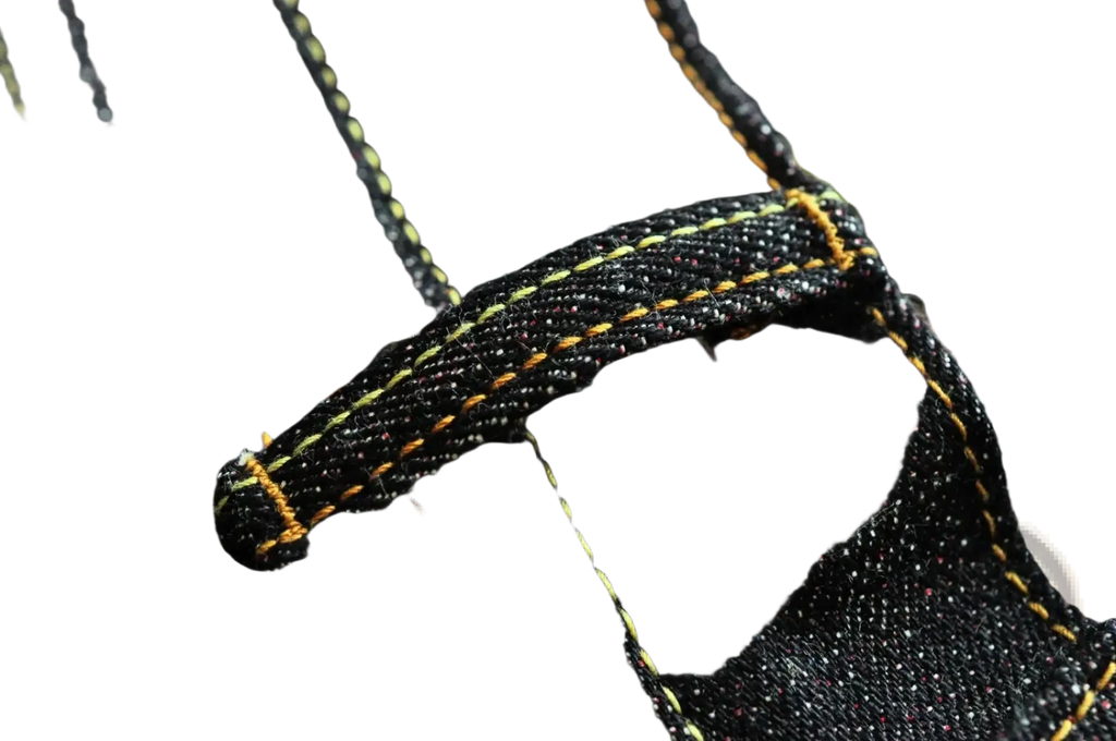 Saucezhan fire selvedge tapered raw denim jeans in dark indigo with yellow stitching and subtle speckled texture
