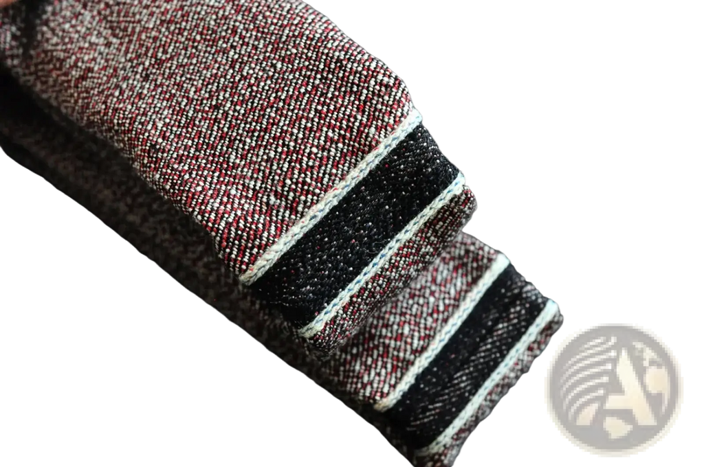 Saucezhan Fire Selvedge tapered raw denim jeans in dark denim with red and white woven cuff and black contrast stitching