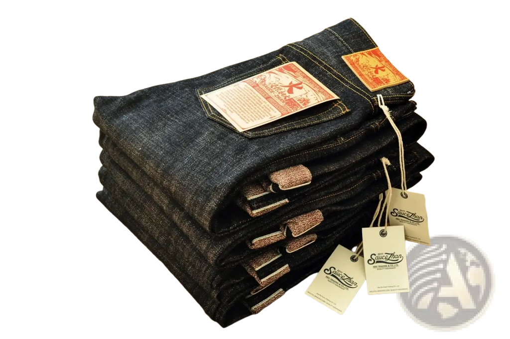 Stack of dark indigo saucezhan fire selvedge tapered raw denim jeans with orange and white brand tags visible