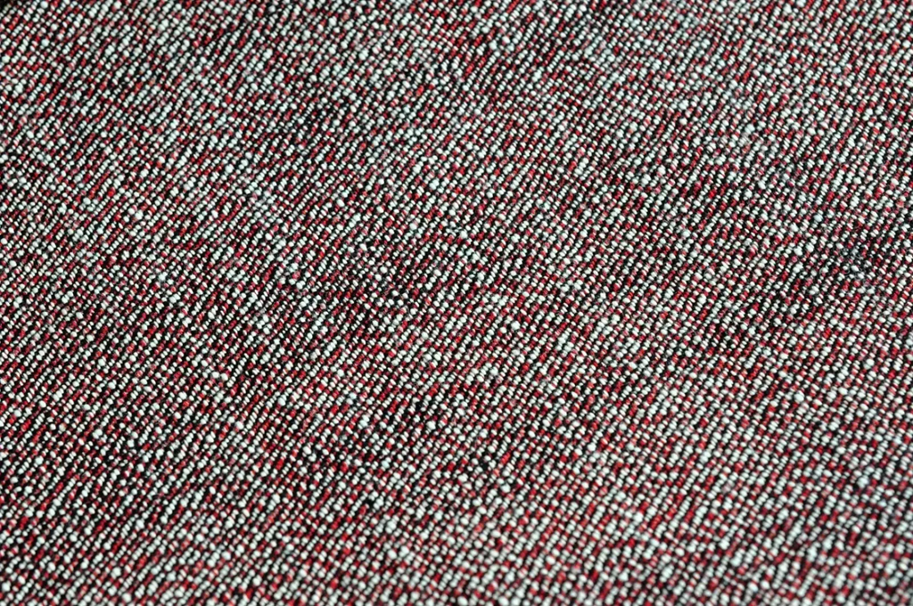 A textured red and white woven fabric with a subtle diagonal pattern used in saucezhan fire selvedge tapered raw denim jeans