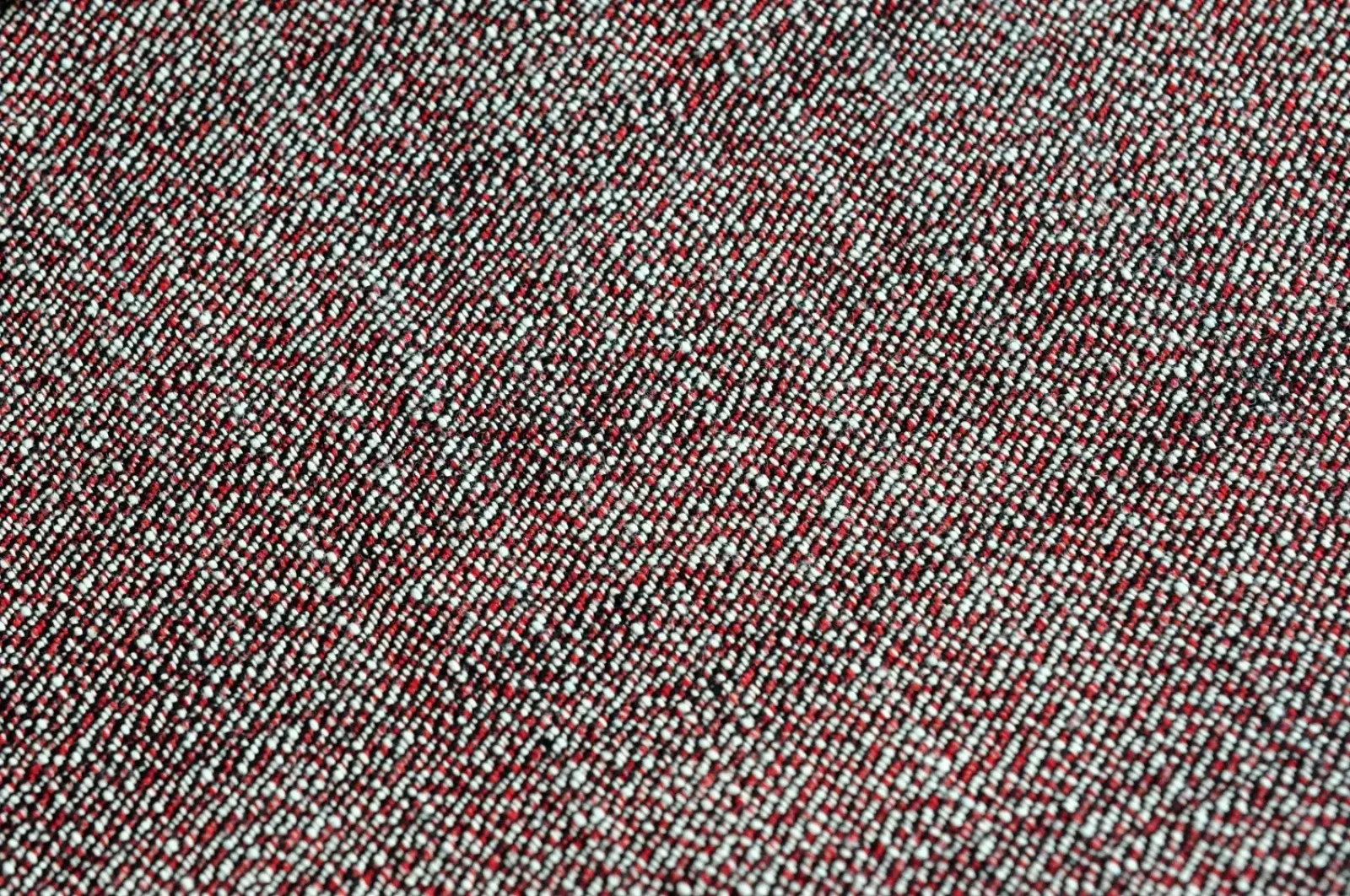 A textured red and white woven fabric with a subtle diagonal pattern used in saucezhan fire selvedge tapered raw denim jeans