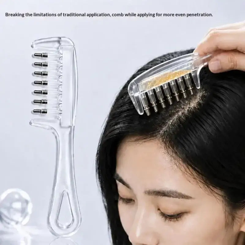 Clear plastic scalp massage applicator brush with metallic bristles and golden beads for essential oil use