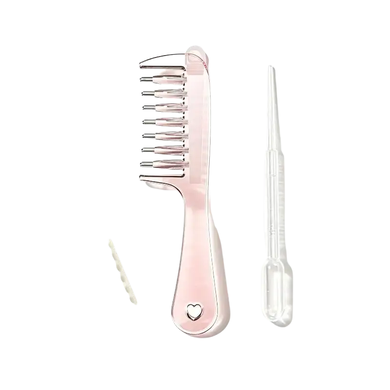 Pink plastic scalp massage applicator brush with metallic silver teeth and heart accent for essential oil use