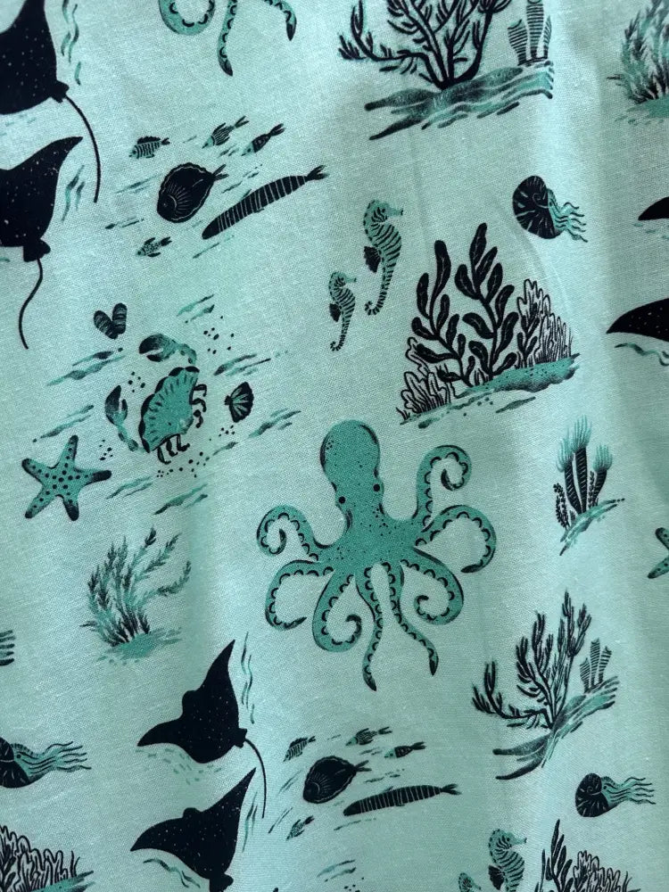 Sea skater a-line cotton skirt in light green with playful black and teal underwater sea creatures print