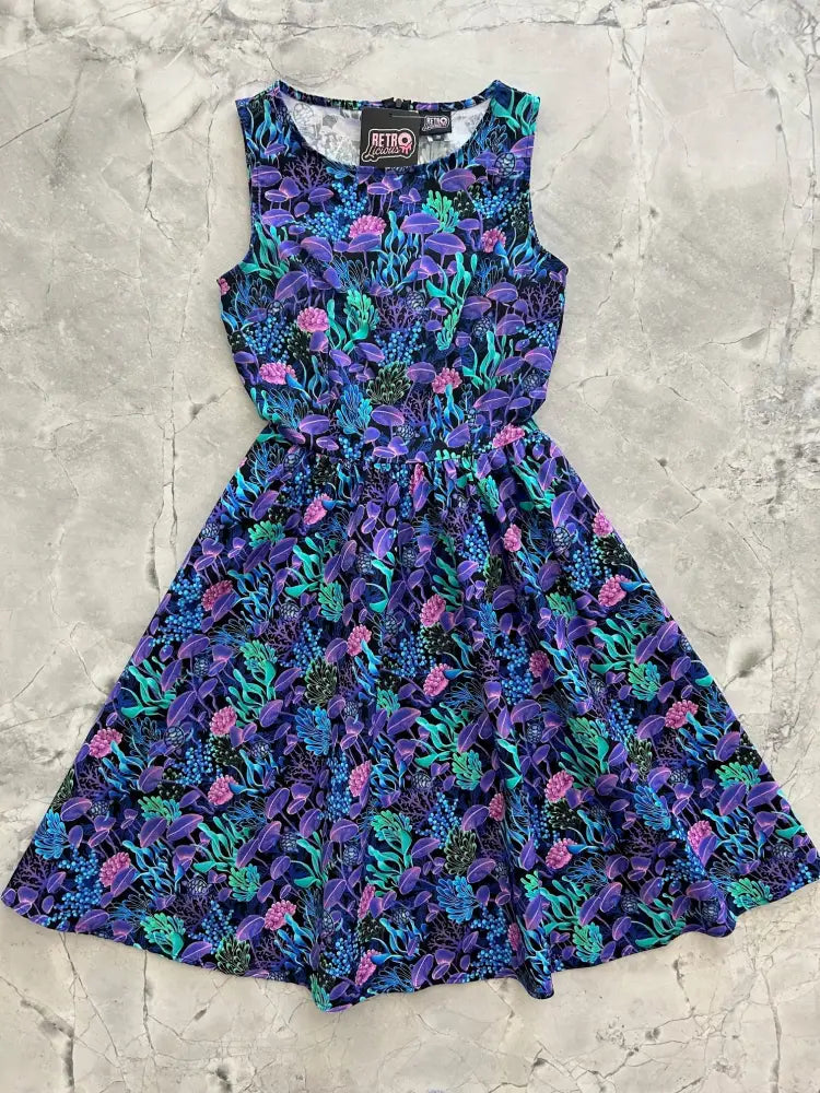 A sleeveless sea vintage neon tropical cotton a-line dress in vibrant purple and teal with pink floral pattern