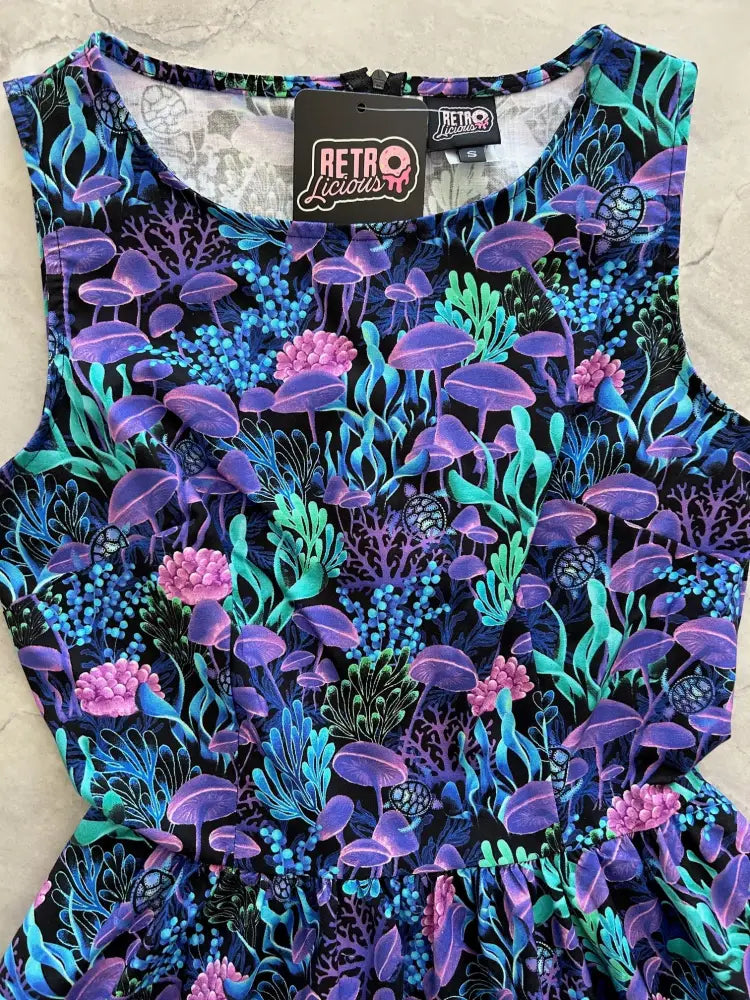 A vibrant sleeveless sea vintage neon tropical cotton a-line dress with purple and teal psychedelic mushroom print on black