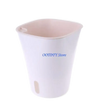 White plastic self watering flower pot with light pink interior and small side drainage hole for nursery use
