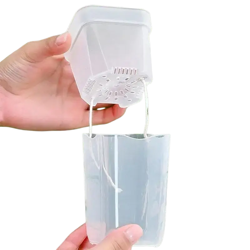 Transparent plastic self watering plant pots with perforated bottom and white strings for hanging suspension