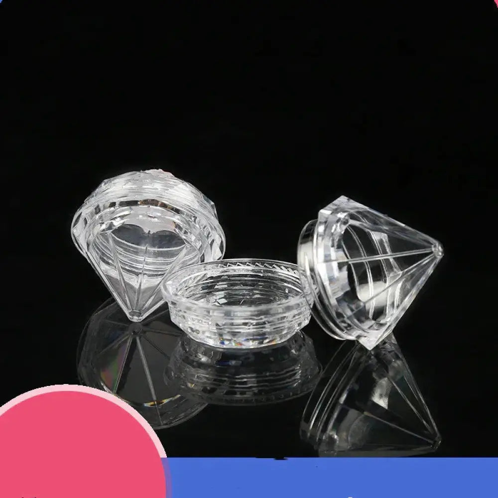 Clear faceted diamond shaped glass refillable travel cosmetic bottles with intricate cut patterns and reflective surfaces