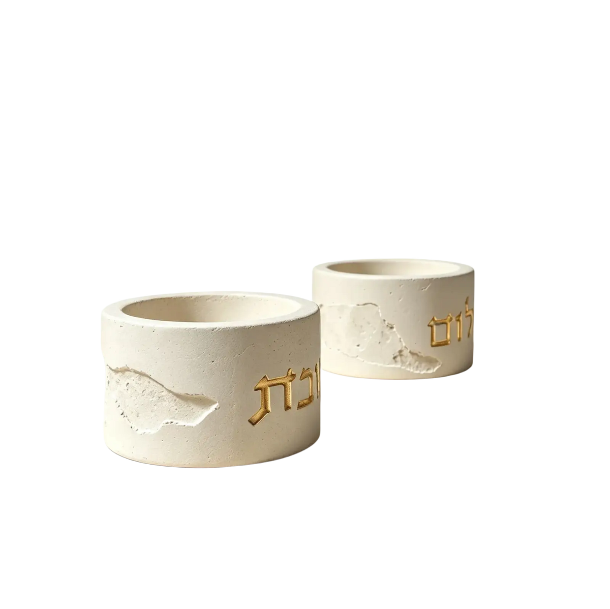 White concrete shabbat candle holders with gold Hebrew lettering and textured cracked surfaces for candle mold