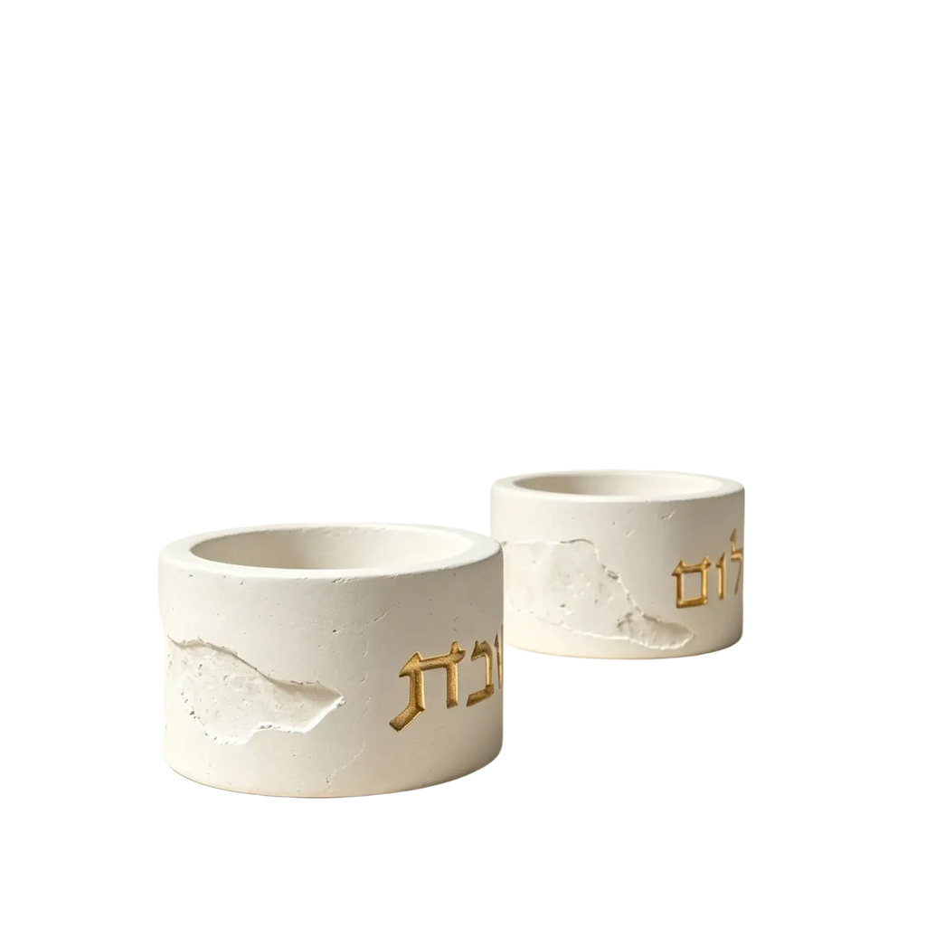 White concrete shabbat candle holders with gold hebrew lettering and textured cracked surface finish molded from silicone