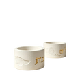 White concrete shabbat candle holders with gold hebrew lettering and textured cracked surface finish molded from silicone