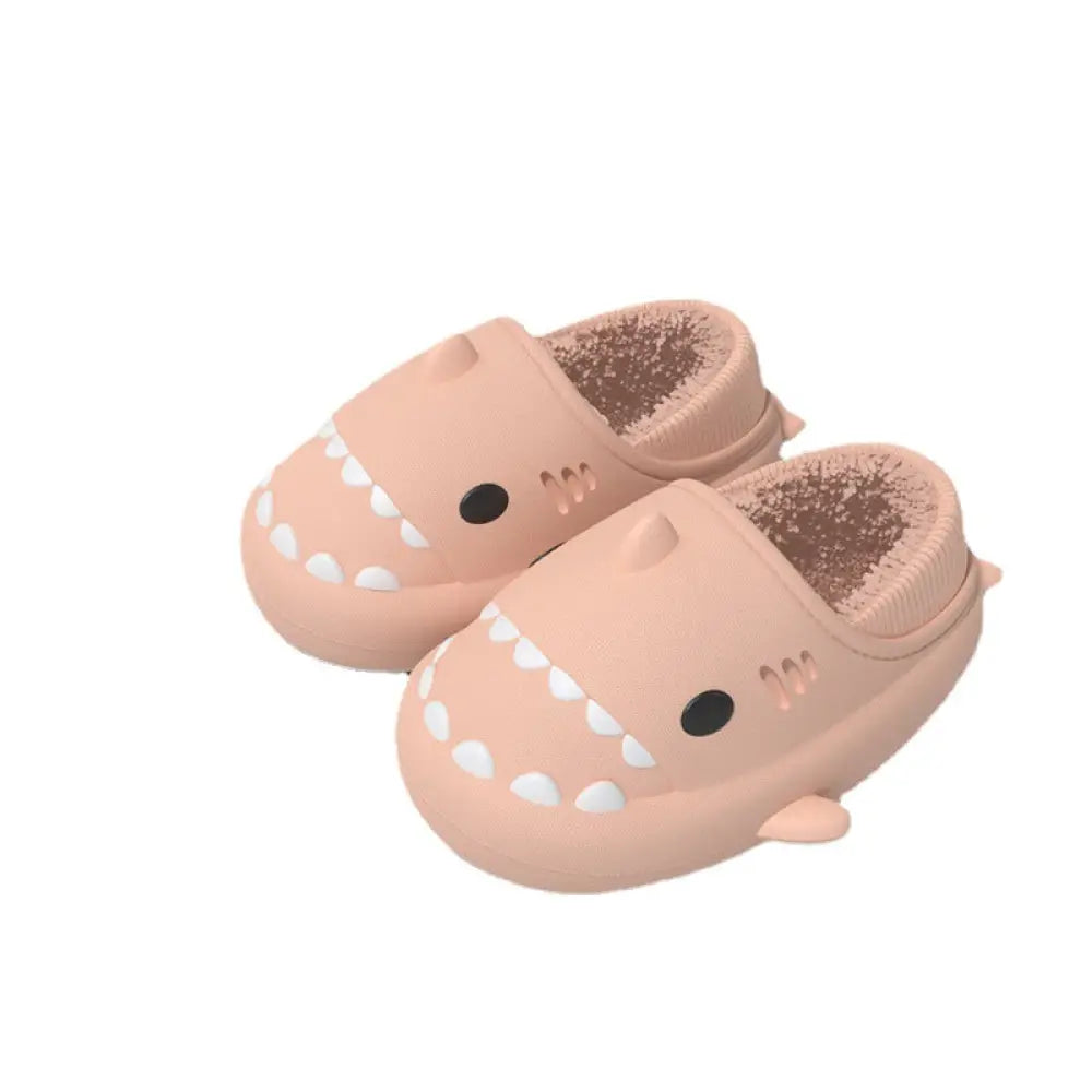 Plush shark winter house slippers in pink with white teeth and black eyes made of soft rubber material