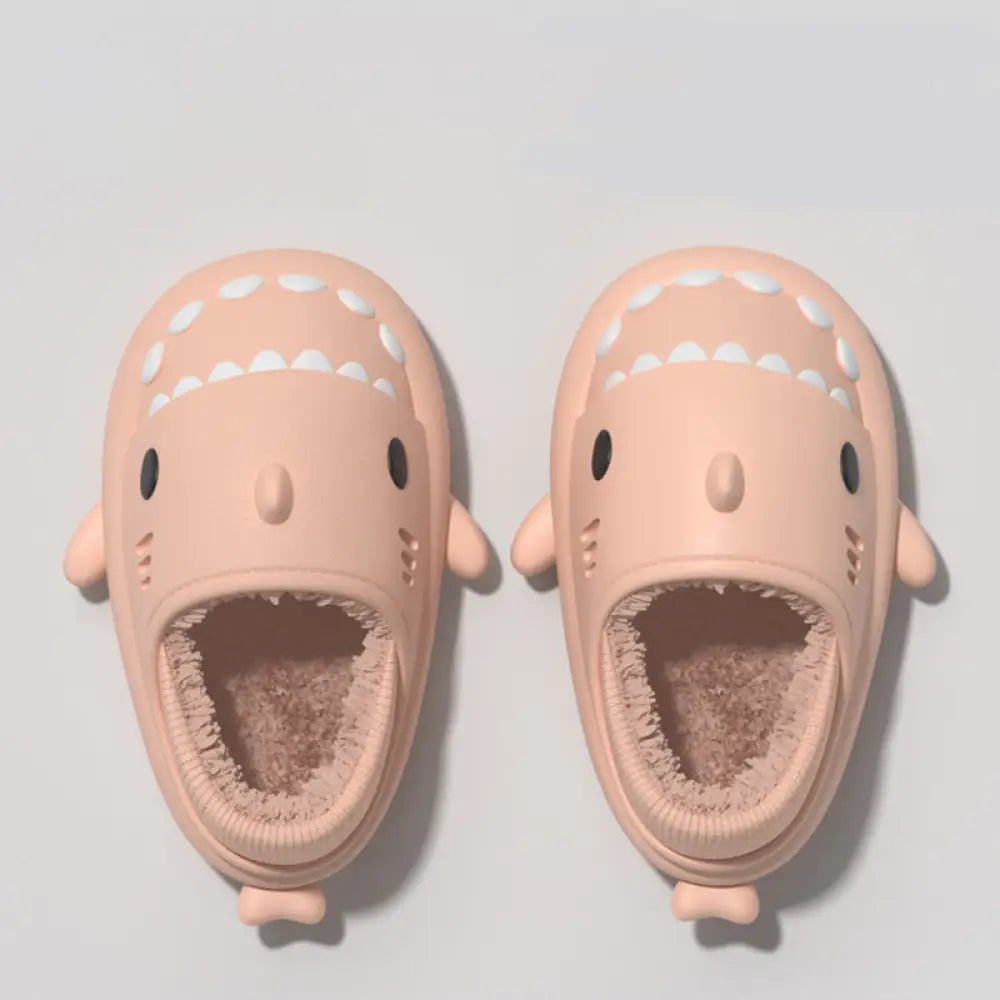 Plush pink shark winter house slippers with white teeth black eyes and soft brown fleece interior and rubber soles