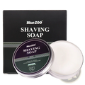 Bluezoo mint-scented shaving soap in a silver tin with black and green label beside its matching box for men’s moisturizing sandalwood cream