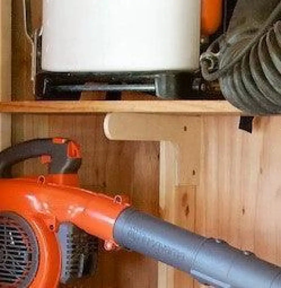 Orange and black handheld leaf blower with gray flexible hose attached shown with heavy duty stud mount steel shed shelf brackets kit