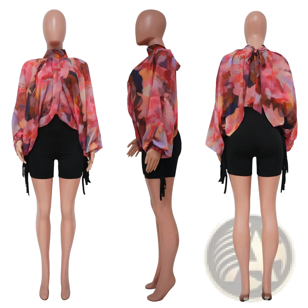 Sheer chiffon blouse with vibrant pink orange and purple abstract floral print featuring long sleeves and side ties