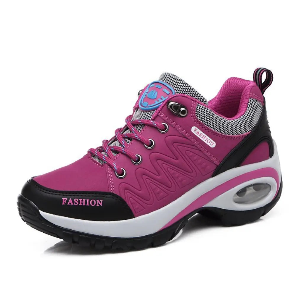 Women’s purple and black hiking shoe with mesh accents cushioned air unit and fashion branding on the side