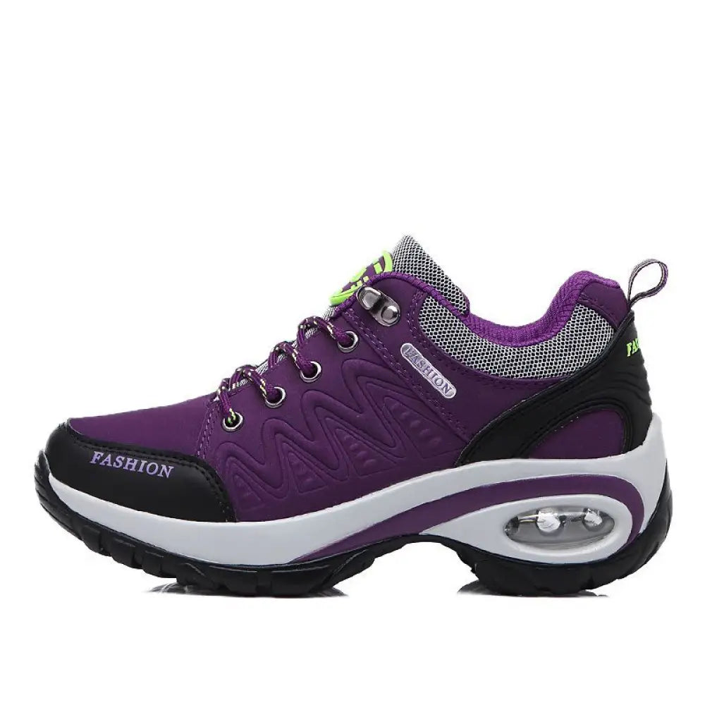 Women purple and black athletic hiking shoe with white midsole and air cushioning unit in the heel showing back side