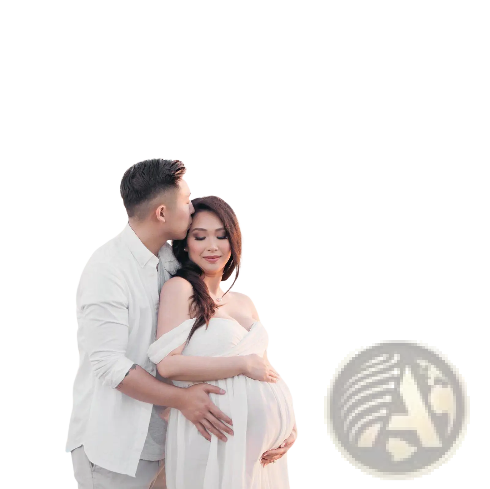 A pregnant woman wears a flowing white off the shoulder chiffon maternity gown by the ocean for photoshoots