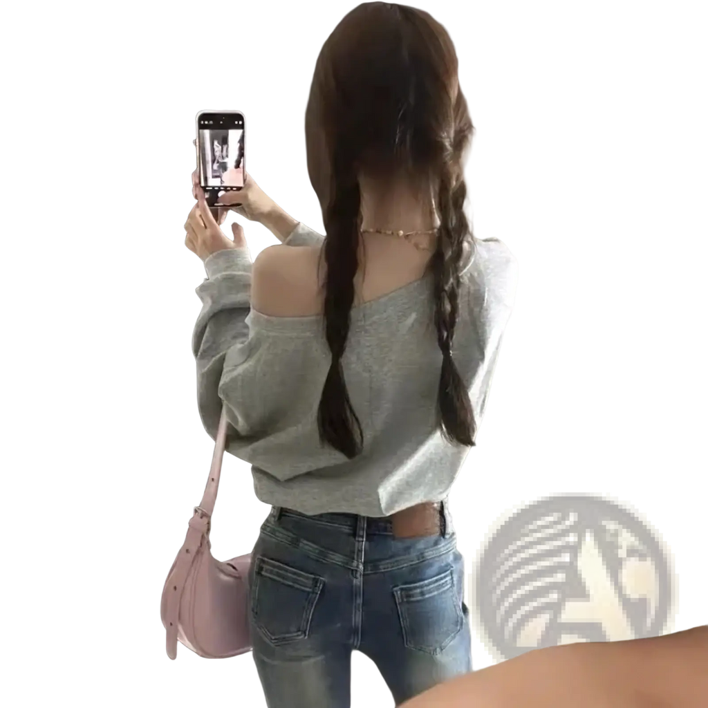 Pink shoulder bag with soft structured design and subtle stitching details paired with off shoulder gray rhinestone sweatshirt