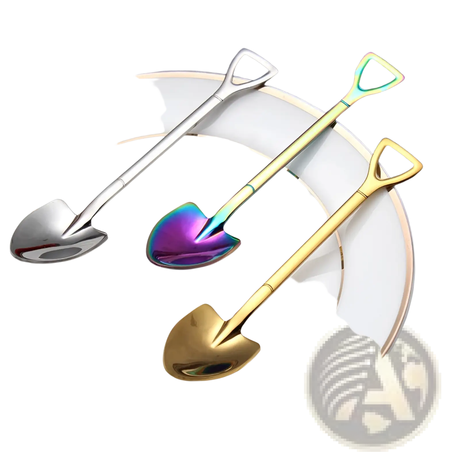 Three stainless steel shovel spoon dessert forks in silver, gold, and iridescent finishes resting on a white plate