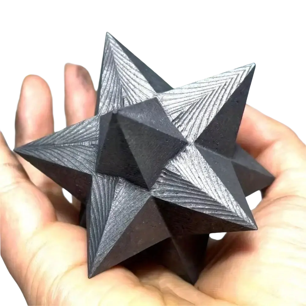 A dark gray shungite merkaba crystal with intricate geometric engravings for elegant home decor and decoration style
