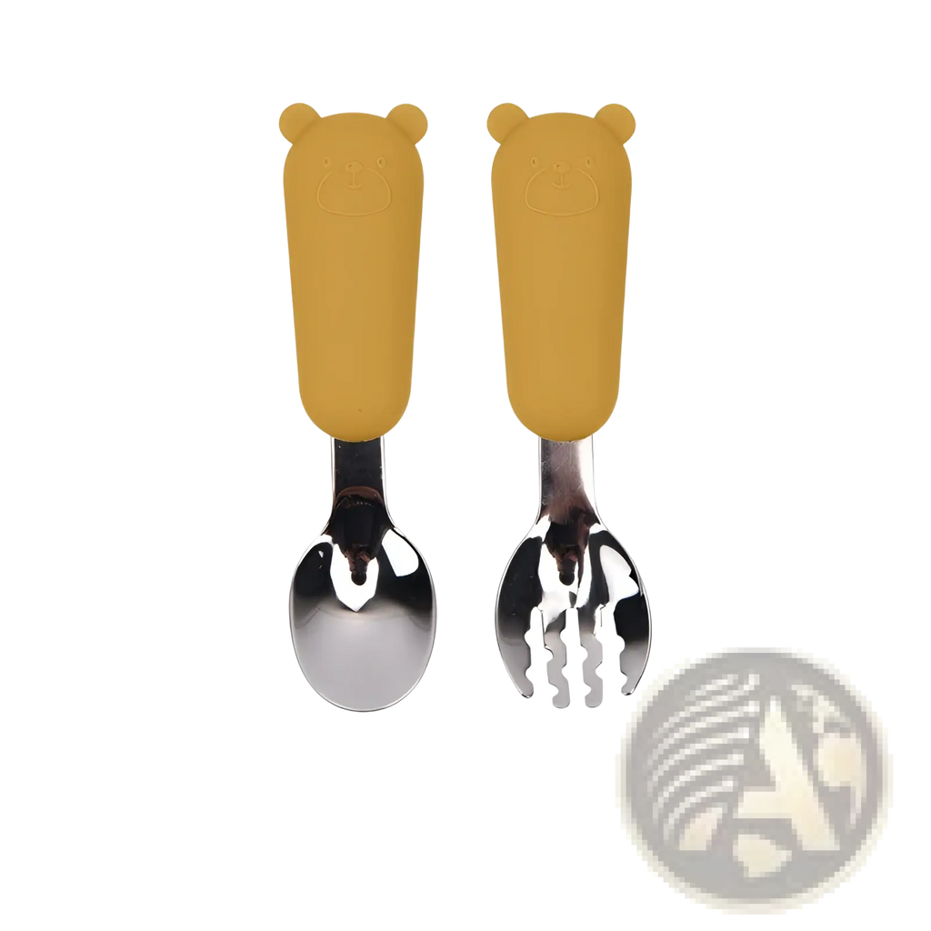 Silicone baby spoon and fork cutlery set with yellow bear-shaped silicone handles on stainless steel utensils