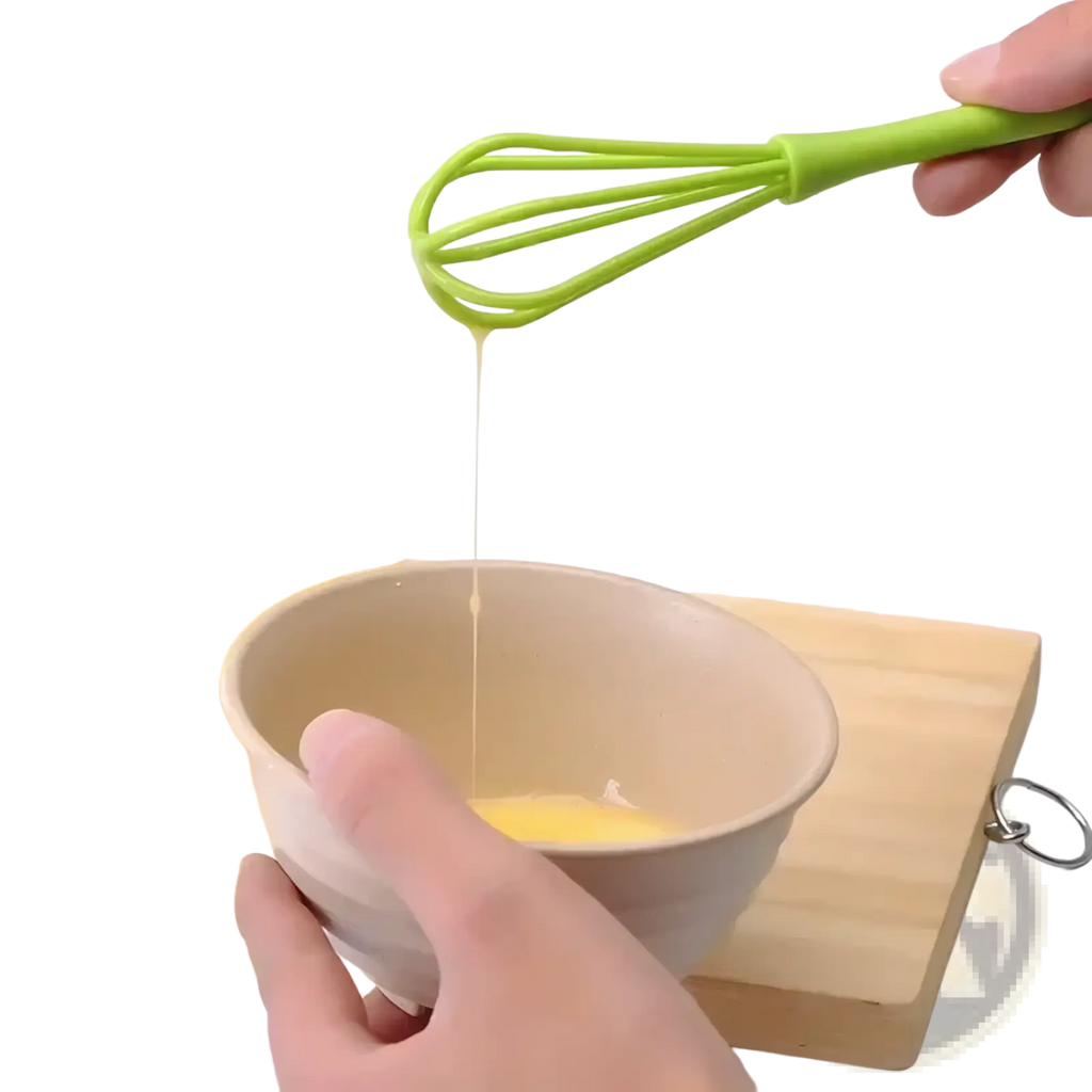 Bright green silicone egg whisk mixing egg mixture in a beige bowl kitchen hand mixer tool