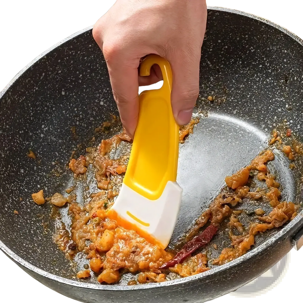 Yellow and white silicone kitchen pan scraper and dish cleaner tool with curved handle stirring food in a pan