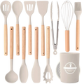 Beige silicone kitchen utensil set with light wood handles and matching beige ceramic storage cup
