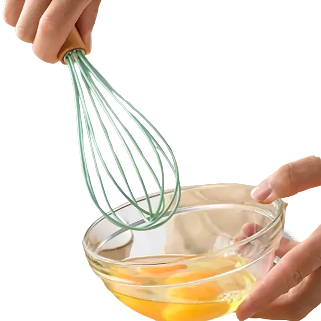 A mint green silicone whisk with a wooden handle from the silicone kitchen utensil set beating eggs in a glass bowl