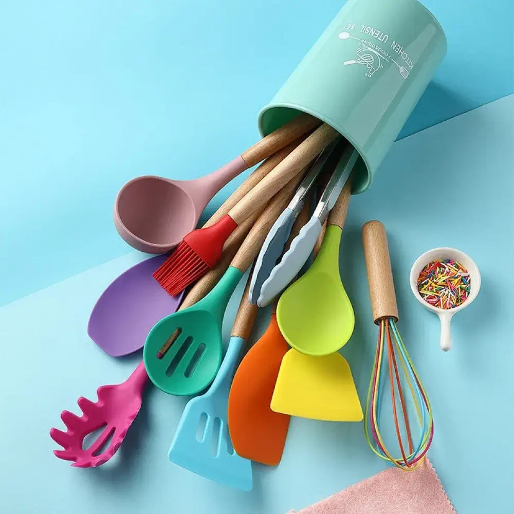 A vibrant silicone and wood heat resistant cooking utensil set with pastel mint cylindrical storage container