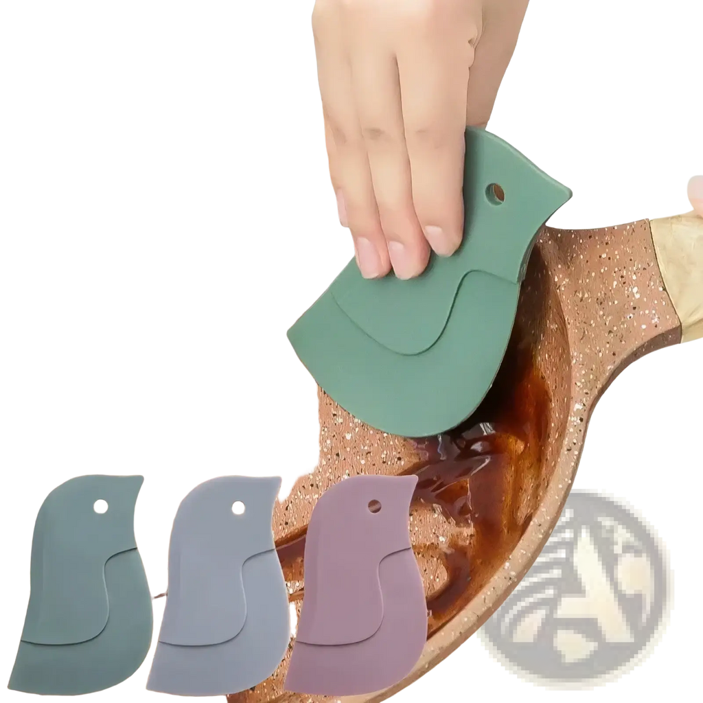 Green silicone bird-shaped silicone pan scraper and grease cleaning tool scraping batter from a pan