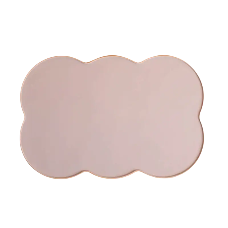A pale pink silicone pet feeding mat with a soft matte finish and wavy cloud-shaped edges