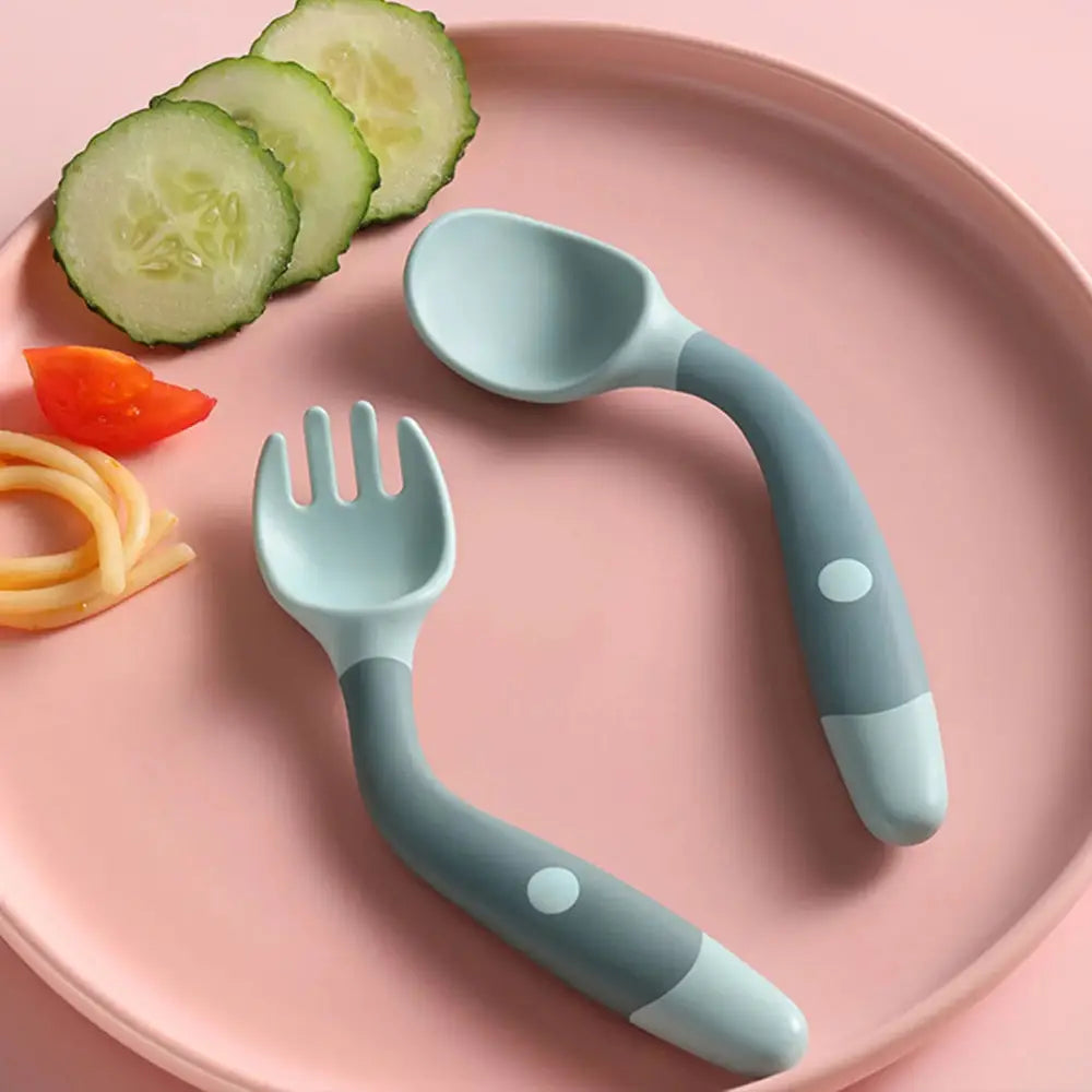 Soft silicone baby spoon and fork self feeding set in light blue and gray with rounded handles and white circular accents