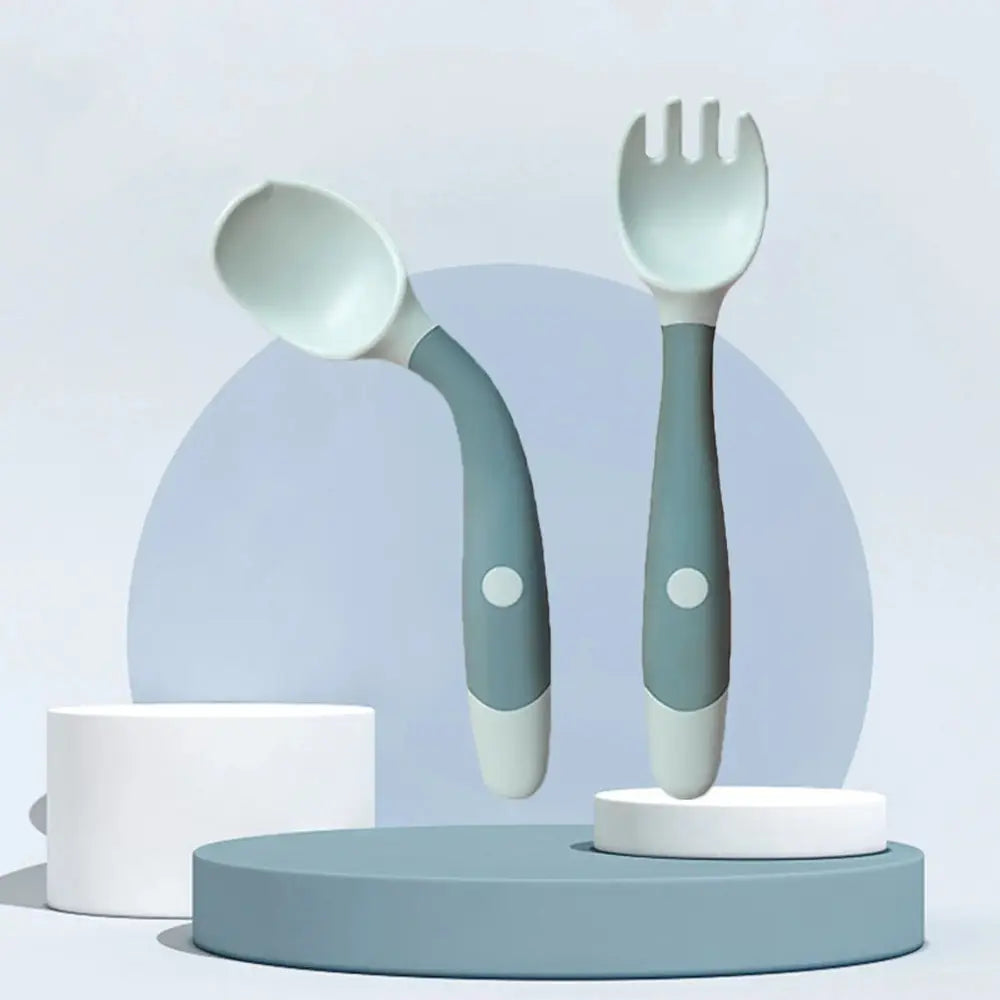 Soft silicone baby spoon and fork self feeding set with soft silicone heads and ergonomic handles in muted gray and white