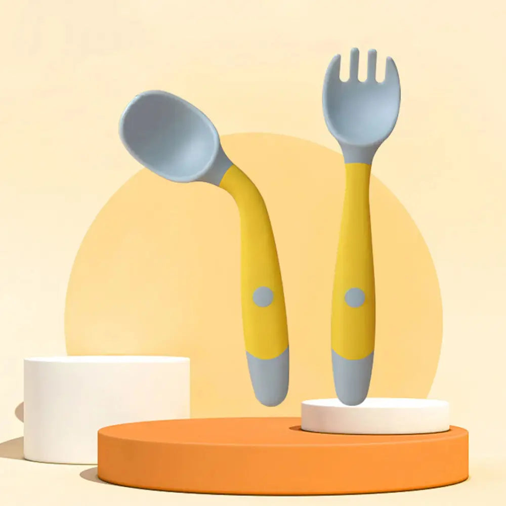Soft silicone baby spoon and fork self feeding set in yellow and gray made for easy baby feeding