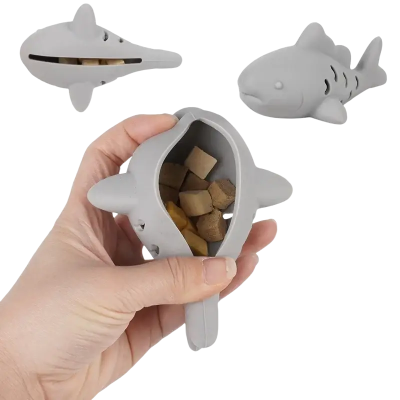 Gray silicone shark-shaped treat dispensing fish toy filled with cat treats for small pets