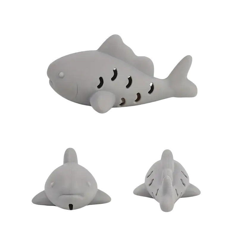 Grey silicone shark-shaped treat dispensing fish toy with perforated body and smooth rounded design for small pets