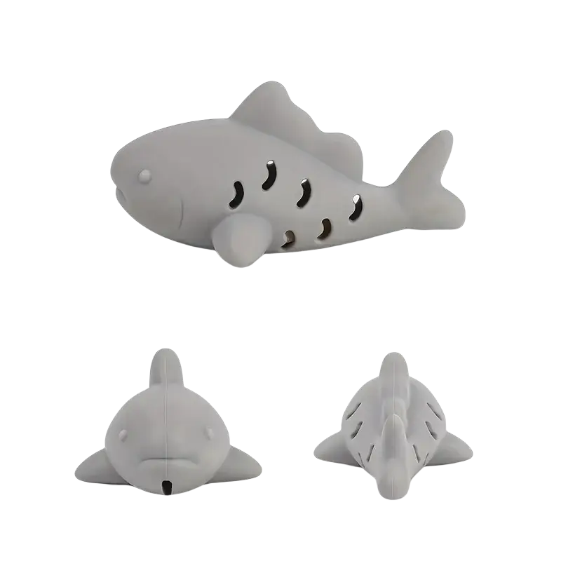 Grey silicone shark-shaped treat dispensing fish toy with black crescent moon cutouts for small pets