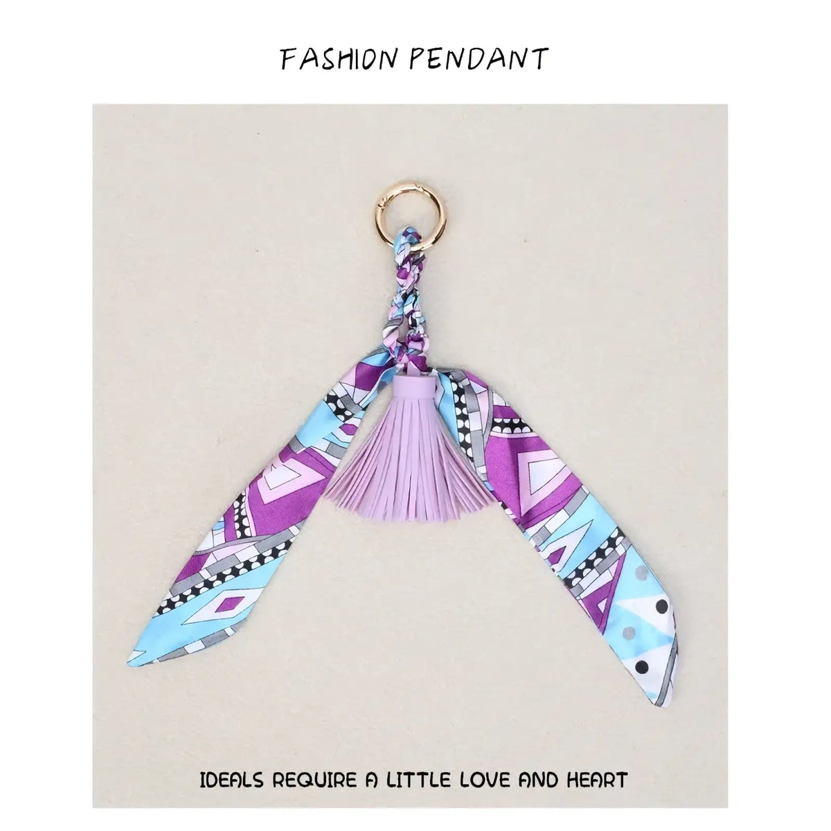 Silk scarf tassel keychain for bags with a purple and blue patterned fabric pendant and a light pink tassel