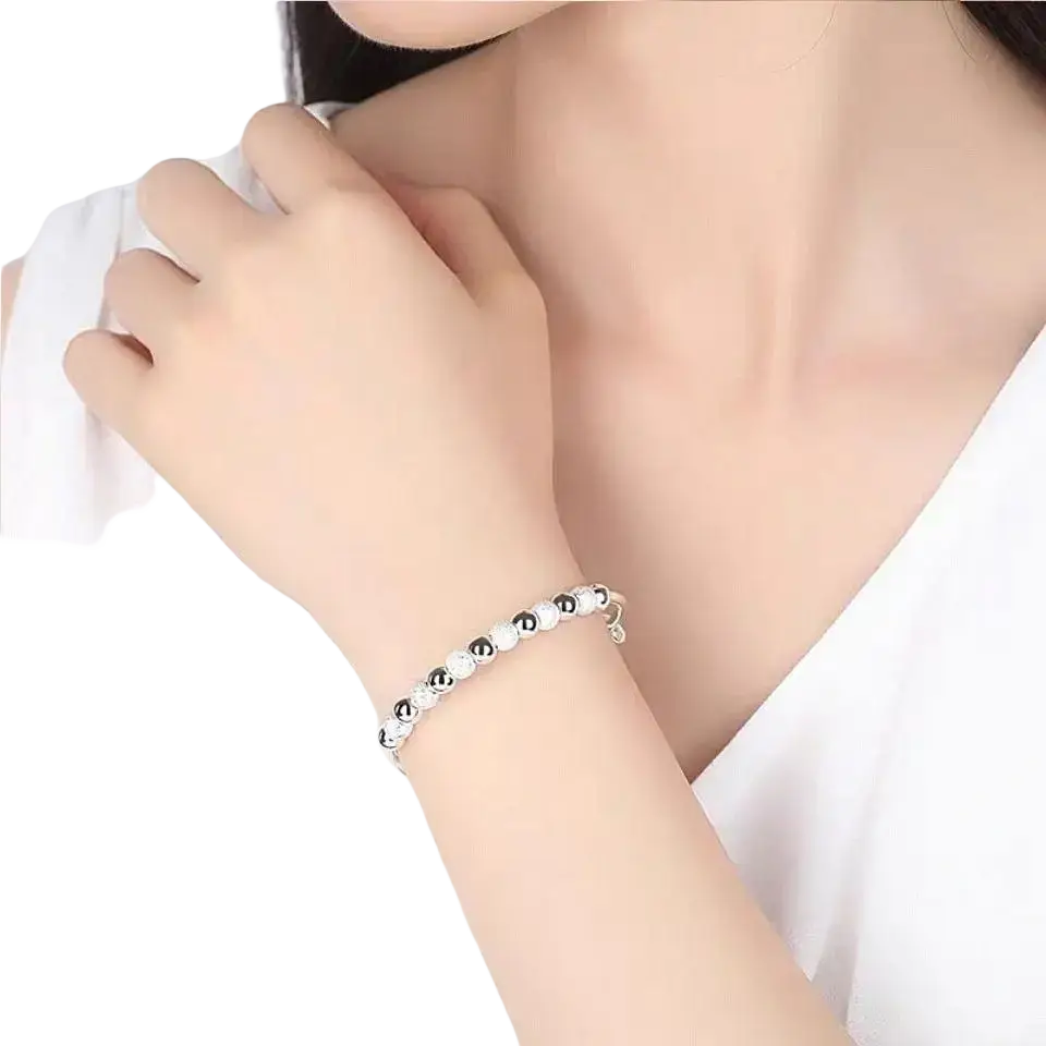Silver bead bangle bracelet for women featuring a sleek silver and black beaded alternating pattern worn on a wrist
