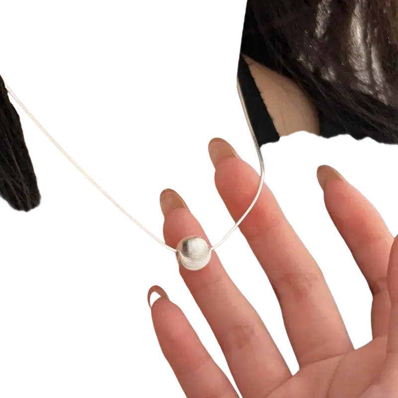 Silver bead pendant necklace featuring a minimalist smooth reflective silver spherical pendant with a delicate chain