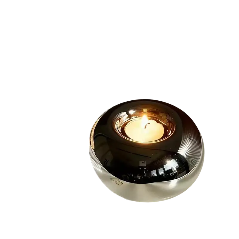 Silver ceramic sphere candle holder with shiny metallic finish and subtle radial grooves on reflective surface