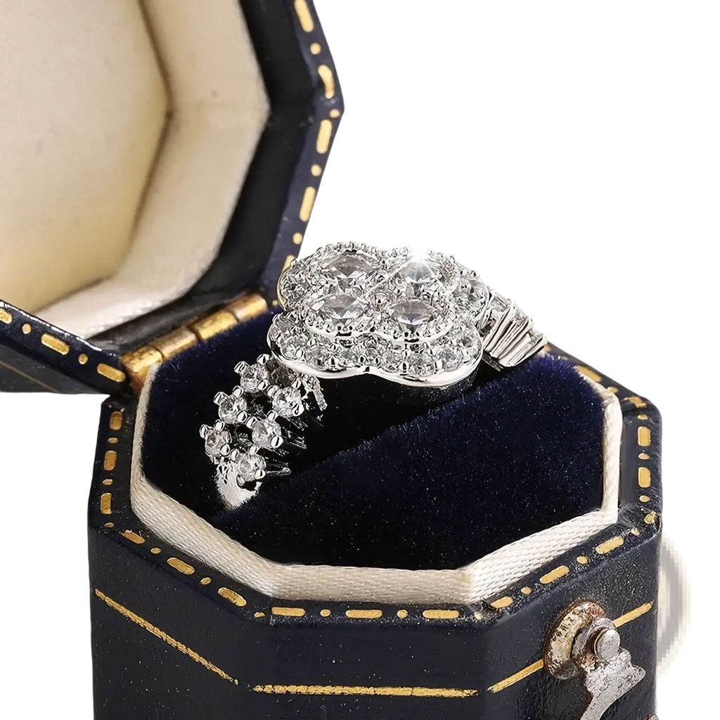 A silver four leaf clover diamond ring with a sparkling cluster of clear stones in an ornate multi-tiered design