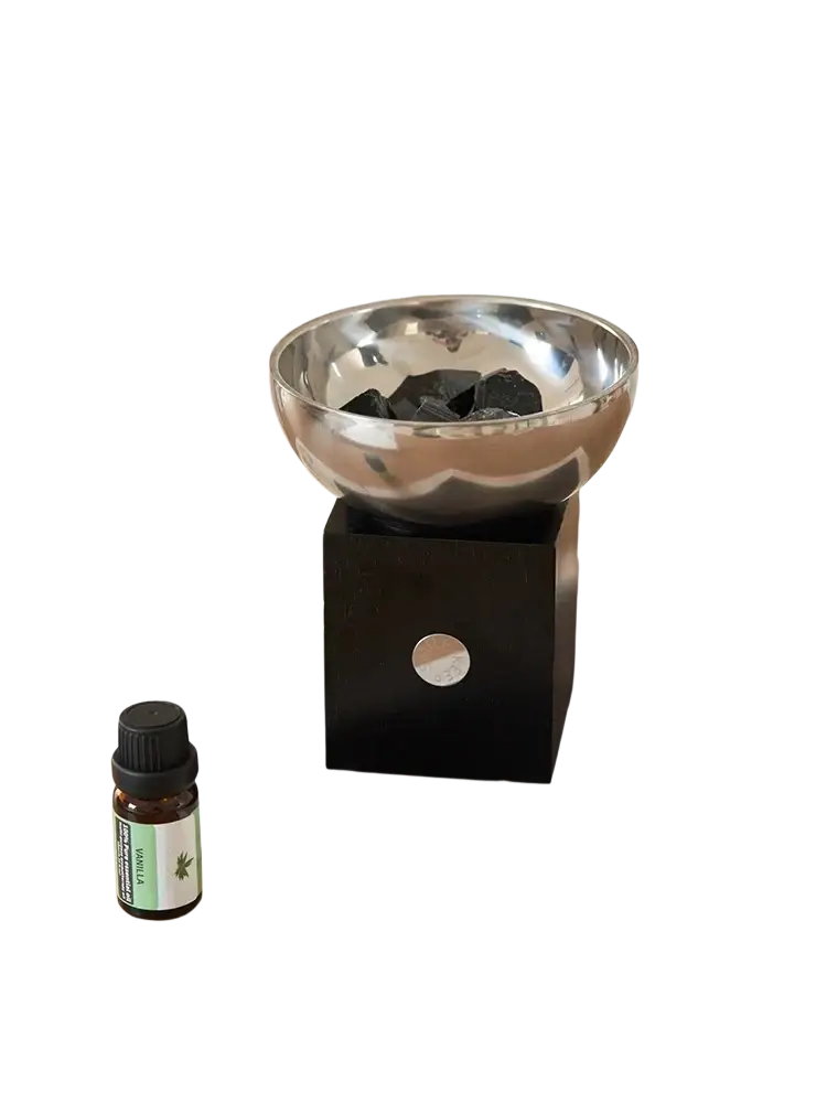 Silver metallic aromatherapy bowl with black stones resting on a sleek black cube base for elegant decor