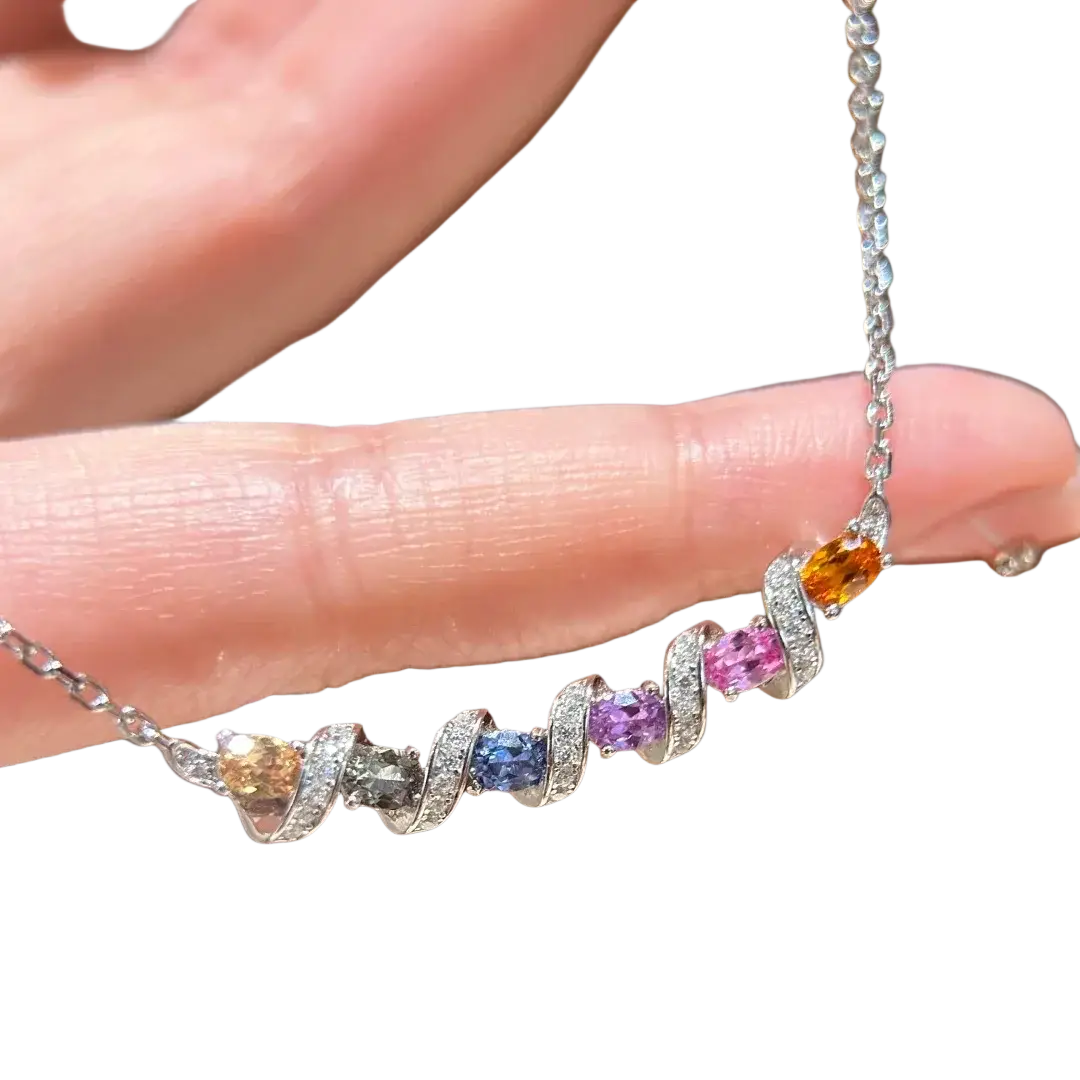 Delicate silver necklace with colorful oval-cut gemstones and pavé diamonds in swirling metalwork geometric pendant